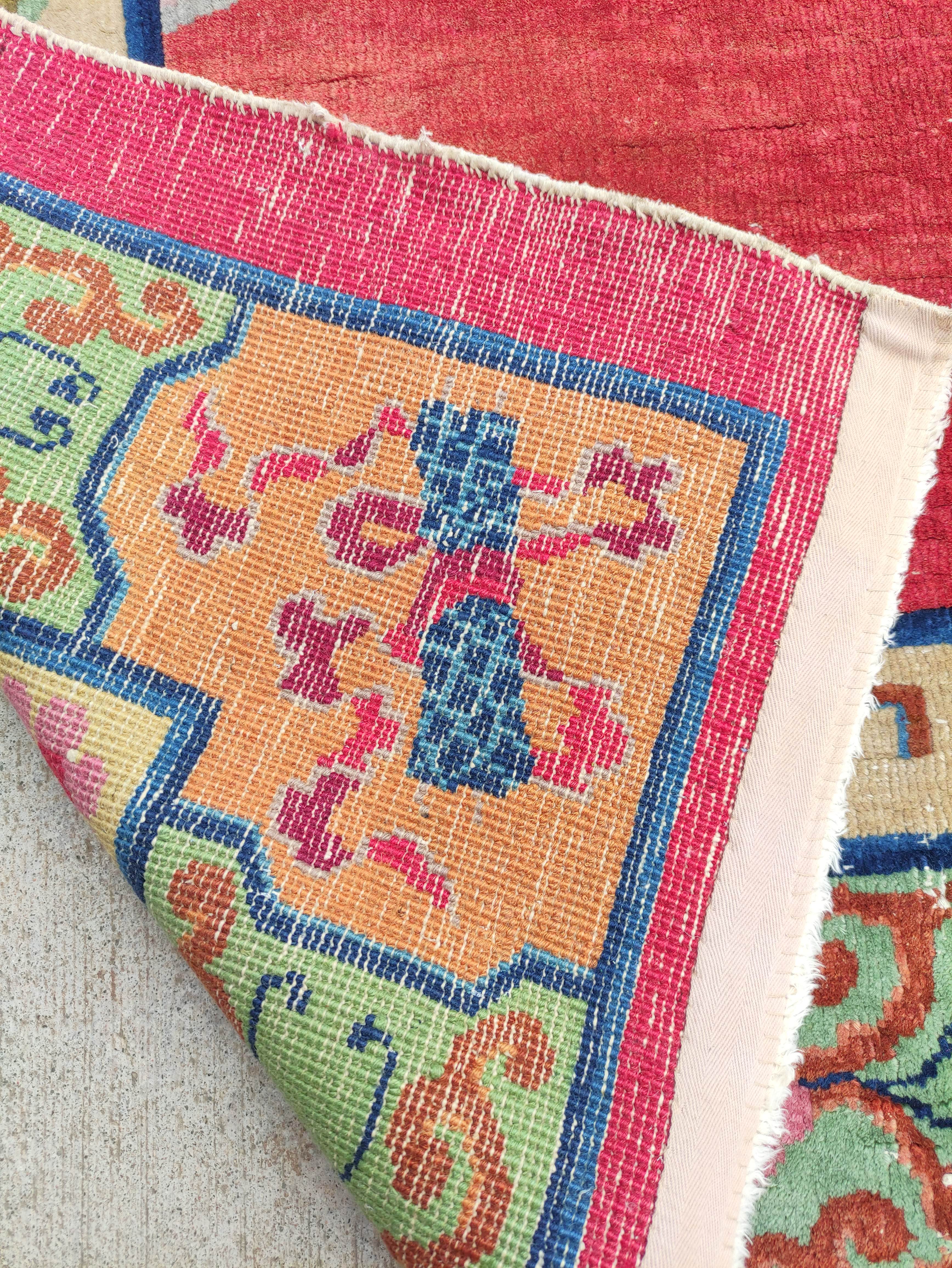 Chinese red ground rug, a deer in the corner below a blossom tree with birds, decorative cream guard - Image 4 of 4