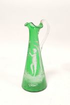 Mary Gregory green glass ewer decorated with white painted image of a boy at a tree, 29cm high.