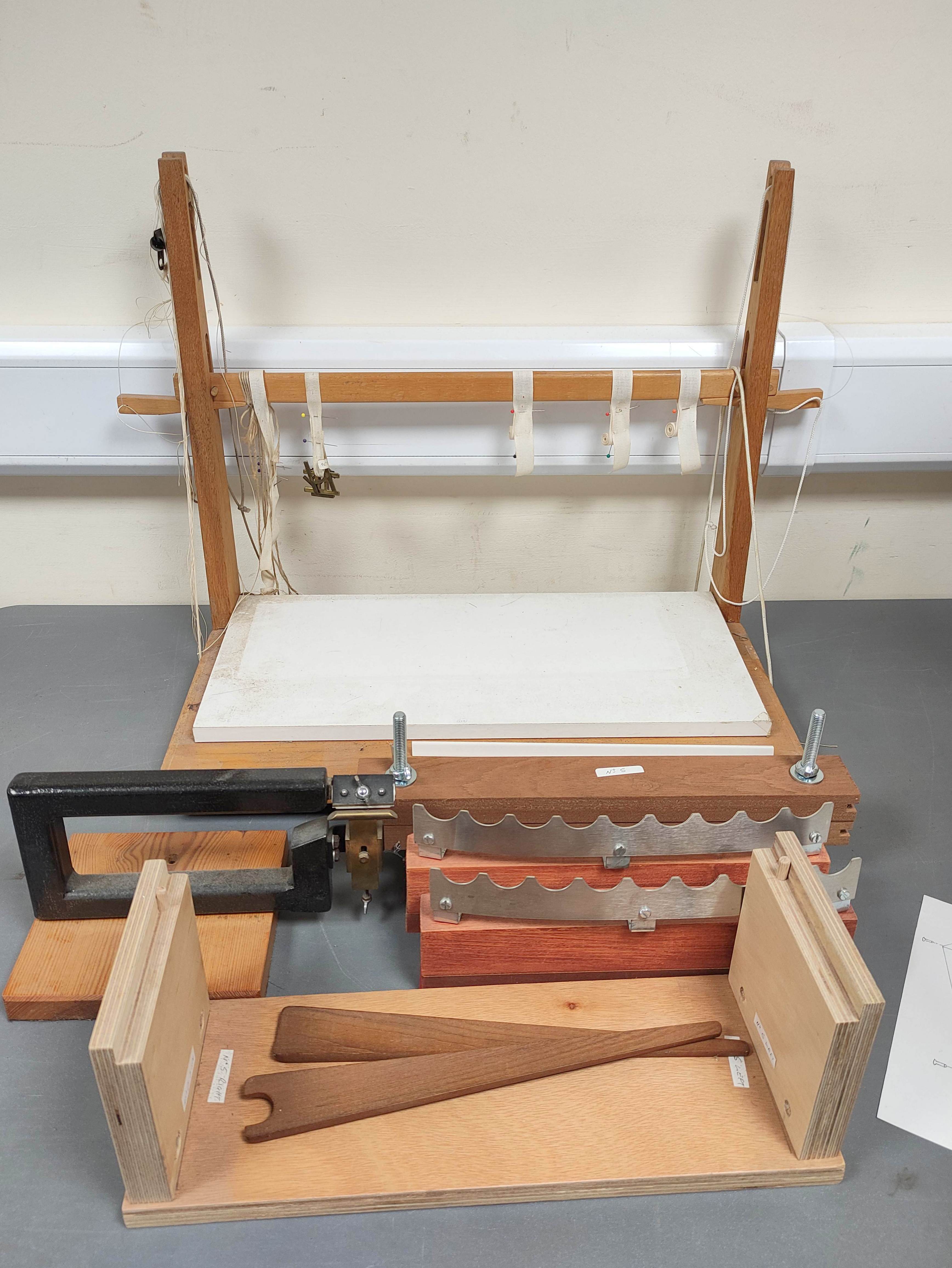 Bookbinding adjustable sewing frame and various rests.