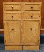 Heals of London, a limed oak cabinet (made up) having four short drawers above two cupboard doors,