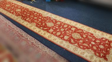 Ziegler style runner, the red field with scrolling floral design framed by cream border, fringed