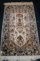 Eastern silk rug, the cream field decorated with central urn of flowers surrounds by flowers and