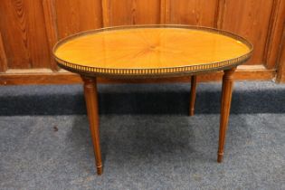 French Empire style oval coffee table with pierced metal gallery, raised on circular tapering fluted