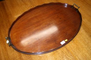 Antique mahogany oval tray with serpentine gallery and twin metal handles, 78cm wide.