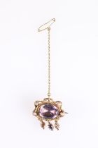 Victorian yellow metal brooch, the central faceted oval amethyst encircled by two snakes guarding