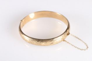 9ct gold hollow bangle with engraved decoration, 13.3g gross.