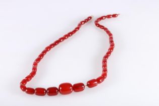 Large single strand necklace of graduated cherry red amber beads, the largest bead over 2.5cm