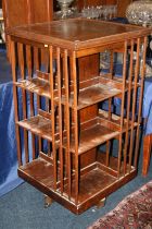 Antique oak revolving bookcase of square section with three tiers of shelves, 115cm tall.