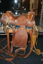 Tooled leather saddle complete with straps and metal fittings by Buffalo Saddle Company.