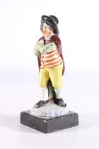 Antique pottery figure modelled as a gentleman wearing a cap and cape, manner of Rathbone of