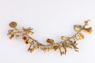 Gold charm bracelet with 23 charms including seahorse, scorpion, heart, key, telephone, elephant,