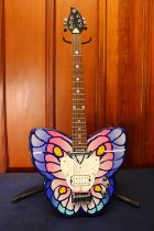 Daisy Rock girl guitar with butterfly shaped design in case, with stand