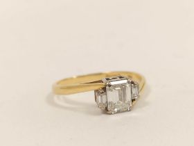 18ct gold three-stone diamond lady's baguette ring, c. 1991, set with a large baguette flanked by