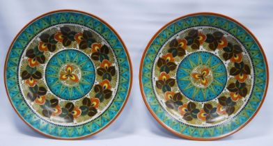 Pair of Gouda Art Deco pattern pottery wall chargers in Dutch folk art decor on a ground of coloured