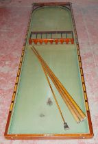 Mahogany tabletop billiard table with cues and numbered rack.