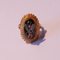 Gold ring with oval cabochon garnet applied with a diamond-set fly, in beaded and twisted mount, the