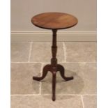 A George III mahogany tripod table, the circular top upon a ring turned baluster column extending to
