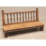 An Anglo-Indian hardwood bench, the balustrade spindled back rest upon a board seat raised upon