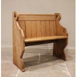 A Victorian pine pew, of cottage proportions, the panel back and board seat raised upon shaped