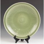 A Chinese Longquan Celadon charger, Ming Dynasty, of circular shallow form, the cavetto incised with