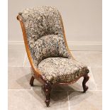 A Victorian mahogany low seat nursing chair, in tapestry style fabric, the curved side rails