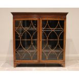A mahogany glazed bookcase, early 20th century, with a dentil cornice above a pair of astragal