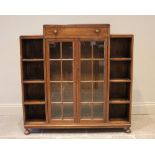 An Art Deco glazed oak bookcase, the architectural shaped top containing frieze drawer with Bakelite