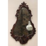 A carved hardwood Florentine style wall mirror, late 20th century, the pear shaped mirrored plate