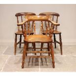 A Victorian elm and beech smokers bow elbow chair, with turned spindles above a shaped seat on