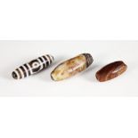 Three Tibetan Dzi beads, each banded agate bead of polished cylindrical form, including a Chung