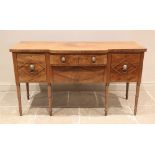 A late George III mahogany breakfront sideboard, the shaped top with a simulated reeded edge above a