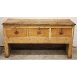 A Victorian pine work bench/dresser, the plank top above three frieze drawers, upon panelled end
