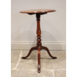 A 19th century mahogany tilt top wine table, the circular top supported by a baluster carved