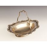 A George V silver swing-handled dish, of oval form with scrolling shaped border and pierced