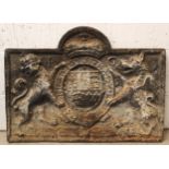 A 17th century style cast iron fire back, 19th century, of break arch form, cast in relief with a