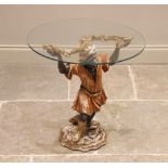 A Blackamoor glass top drinks table, 20th century, the circular glass top raised upon a painted