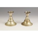 A pair of Dutch silver candlesticks, each sconce upon a stepped bell-shaped weighted base, dated