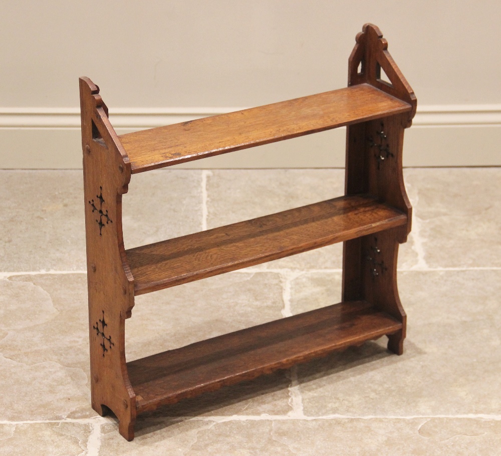 A Victorian ecclesiastical oak wall shelf, the shaped uprights pierced with quatrefoil apertures and