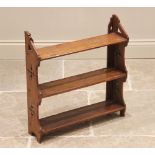 A Victorian ecclesiastical oak wall shelf, the shaped uprights pierced with quatrefoil apertures and