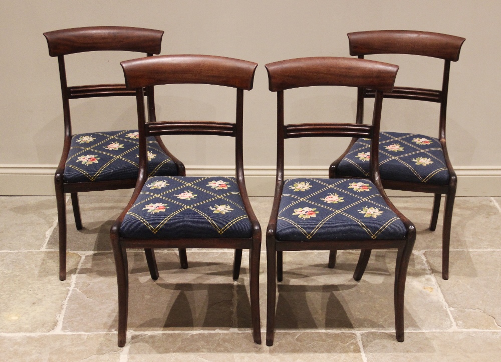 A set of four mahogany rail back dining chairs, mid 19th century, each chair with a concave rail