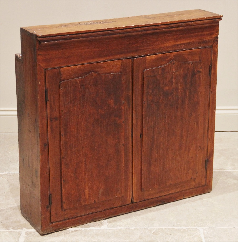 A Victorian stained pine wall mounted ecclesiastical cupboard, of inverted square form, the pair