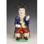 A Staffordshire pottery William Kent type "Squire" Toby Jug, 19th century, the figure with black