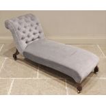 An Edwardian chaise lounge, in blue velour, the button back scroll end extending to a sprung seat,