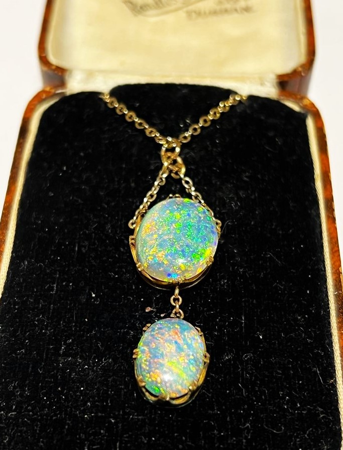 An early 20th century black opal pendant, designed as an oval opal cabochon measuring 17.0mm x 14.