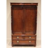 A William IV plum pudding mahogany wardrobe, the moulded cornice and plain frieze over a pair of
