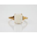 An opal dress ring, the central emerald cut opal doublet measuring 10mm x 8mm, claw set to