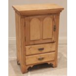 A late Victorian pine side cabinet, the single cupboard door over two drawers, flanked by inset