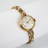 A ladies vintage 9ct gold Tudor wristwatch, the round white dial with Arabic numerals and subsidiary