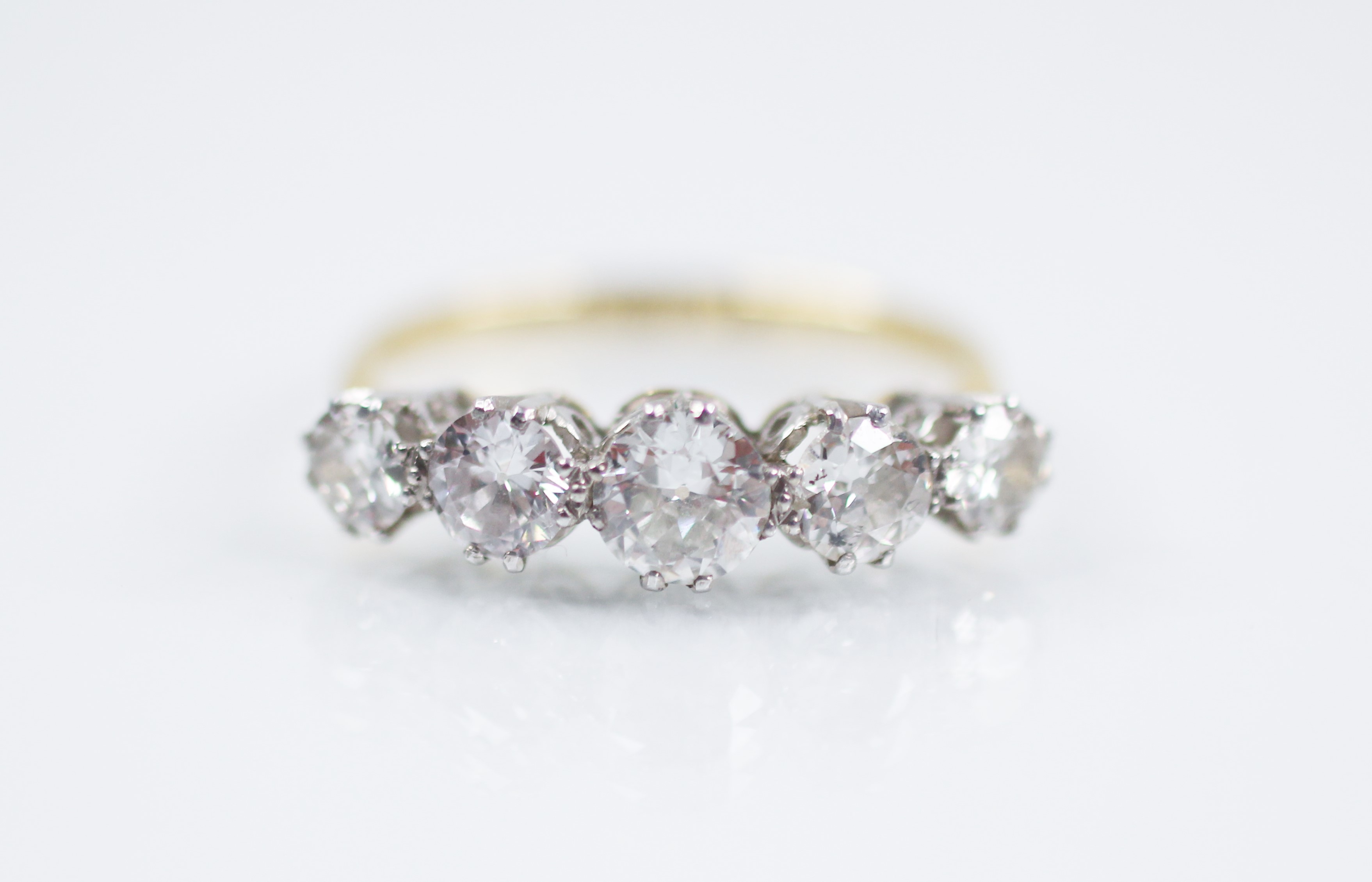 An early 20th century five stone diamond ring, the central round brilliant cut diamond