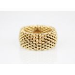 An 18ct gold mesh-link ring, applied pad to interior stamped 'T&CO 750', 11mm wide, ring size P,
